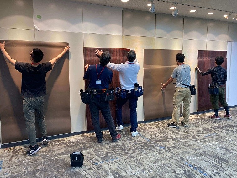 A group of men wrapping the wall.