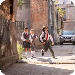 学校から歩いて帰る3人の子どもたち
