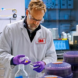 3M製品を検査する3M白衣を着た男性科学者