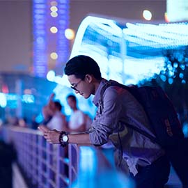 混雑したエリアでスマートフォンを使用する観光客。