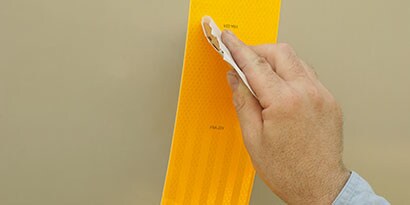 3Mの反射テープを貼付する男性の手
