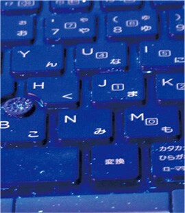 表面異物識別用可視化ライトを使用しＵＶ照射したキーボード （光っているのは、付着した粒子や落下塵）