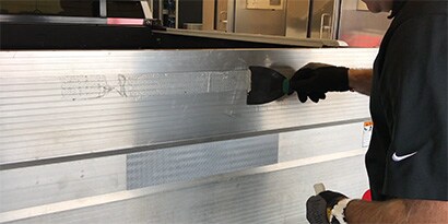 3Mの反射テープの接着剤をはがす人
