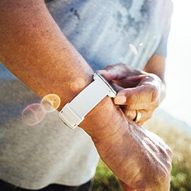 屋外でスマートウォッチを確認する人。