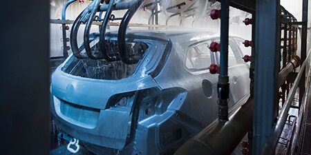 組み立て工程で水洗を通過する自動車の画像。
