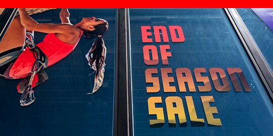Large window graphic showing rock climber and advertising sale.
