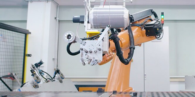 幅広の均等巻きテープを保持するアプリケータヘッド搭載のロボットアーム、画像
