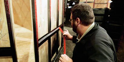 Image of a person applying VHB tape to a trailer panel.
