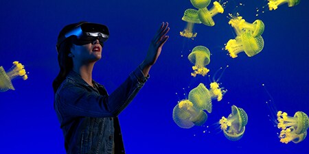 AR/VRヘッドセットを着用して水中を体験している女性
