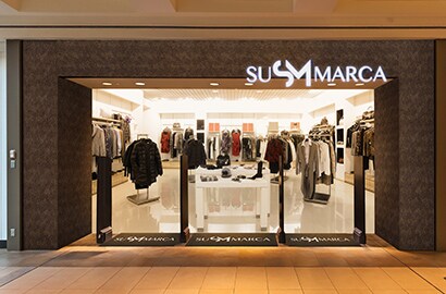 Exterior of retail space with large, dramatic building wrap picturing a track runner.