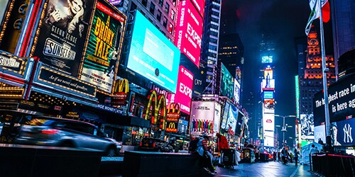 夜空を背景にネオンサインが輝く、カラフルで活気あふれる街並み
