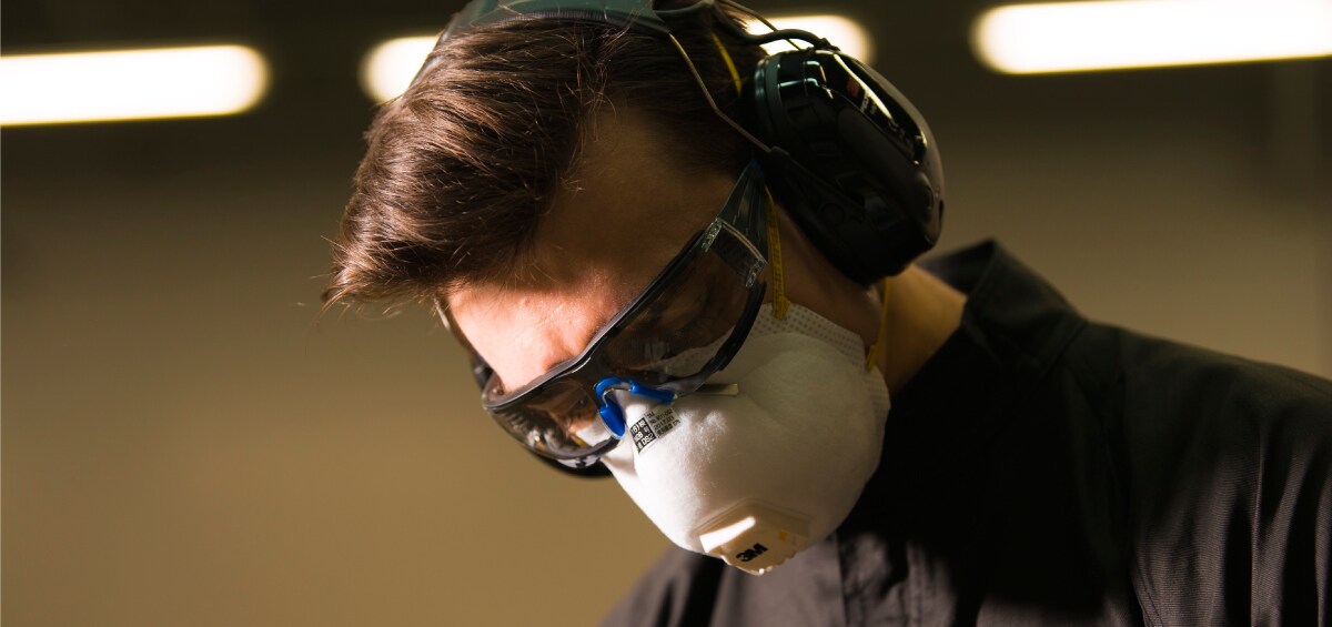 A man wearing eye and hearing protection and a respirator
