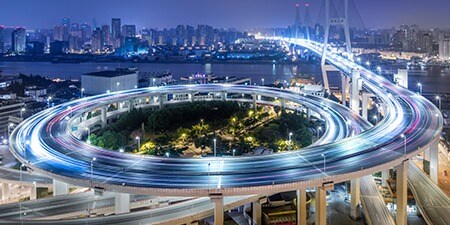 自動車の走行と排出ガスを象徴する大都市郊外の螺旋状の高架橋

