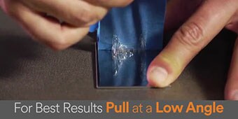 Video still of the demonstrator removing adhesive residue, with the text caption “For Best Results Pull at a Low Angle”
