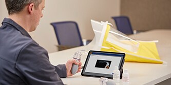 A  man reviewing wearer details on a tablet
