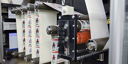 大型プリンター内で循環されているナンバープレートシートの長いロール
