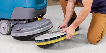 Worker replacing 3M Floor Pad on floor buffer.
