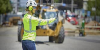 個人用保護具を着用して交通整理をする作業員
