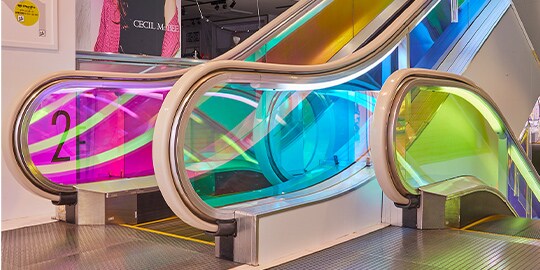 Escalators with colorful glass finishes.
