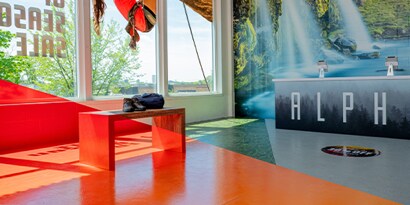 A retail space with the business name in a graphic wrap on the counter and a waterfall on a wall wrap in the background.
