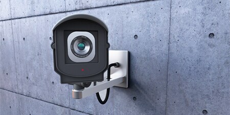 グレーのコンクリート壁に設置された監視カメラ
