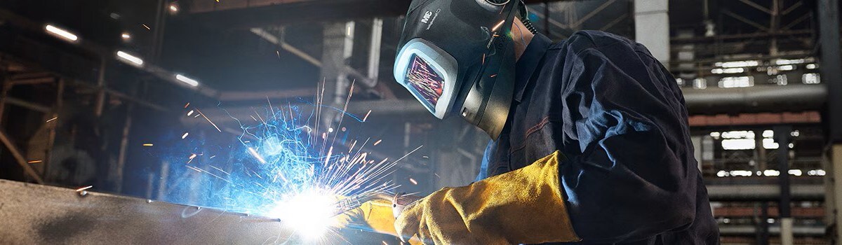 PAPR付き溶接用ヘルメットを着用して溶接する作業者

