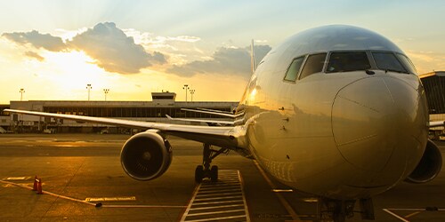 夕日を背景に滑走路に駐機している大型航空機
