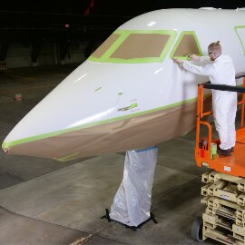 飛行機をマスキングする作業員のイメージ
