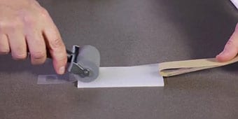 Video still of the demonstrator rolling out the adhesive to ensure wet-out
