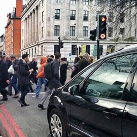 交差点の道路標識と通りを横断する歩行者