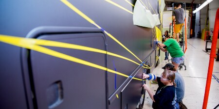 特装車側面をマスキングする作業者のイメージ図
