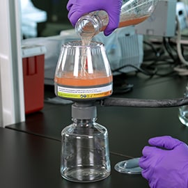 Photo of technician pouring fluid into the bottle top configuration