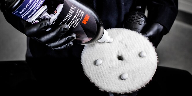作業者が3M™ パーフェクト・イット™ ランダムオービタル コンパウンドをパッドに付けているところ。

