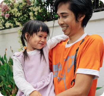 幼い娘を抱きかかえる男性
