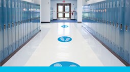 foot print floor graphics for social distancing reminders in a school hallway.
