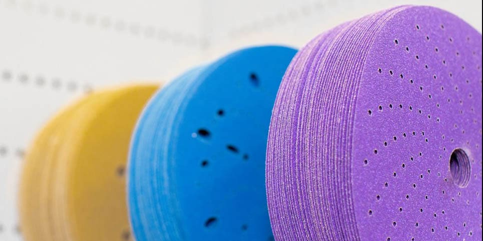 Close-up image of abrasive disks used for grinding and sanding, showing various sizes and textures.
